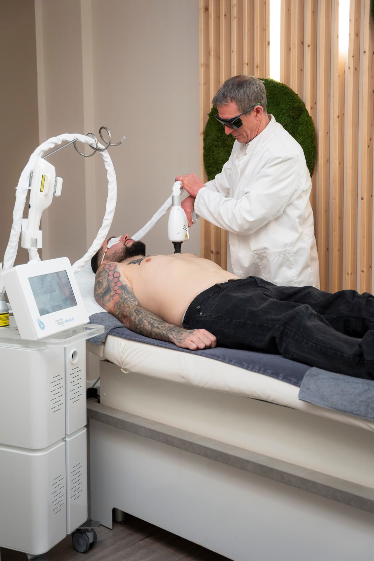 Arzt behandelt einen Patienten mit einem medizinischen Lasergerät